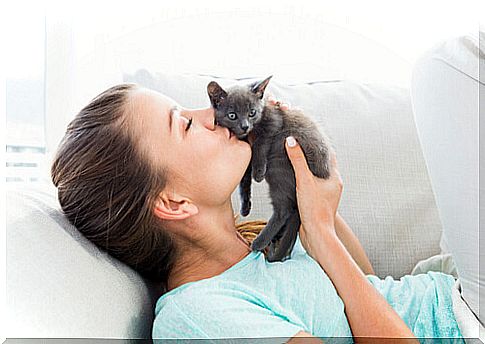 woman kissing kitten