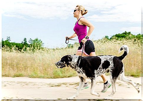 Woman running with her dog in the sand.